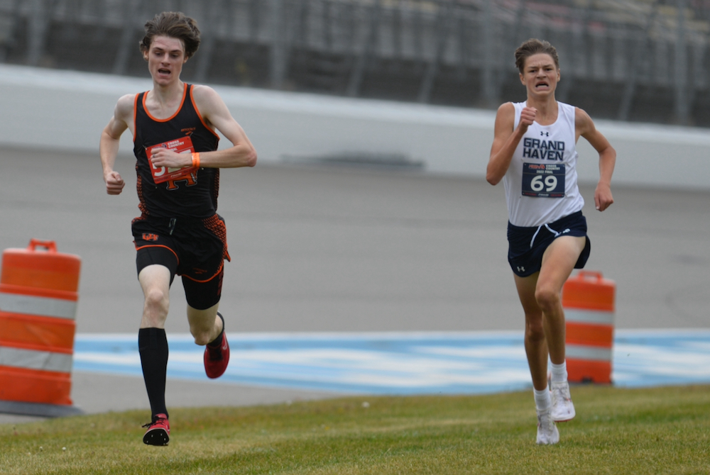 Grand Rapids’ Benne Anderson, left, and Grand Haven’s Seth Norder sprint the stretch of the LPD1 boys championship race. 