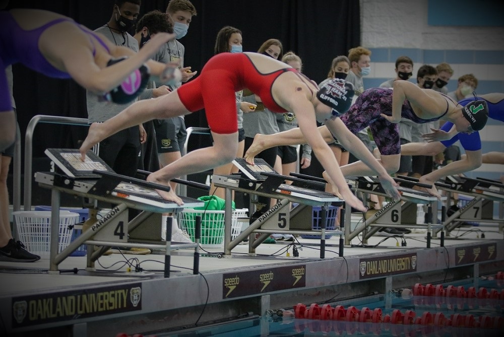Seaholm’s Samantha Clifford, middle, launches into the water for the 100-yard freestyle championship race at last season’s LPD2 Finals at Oakland University. 