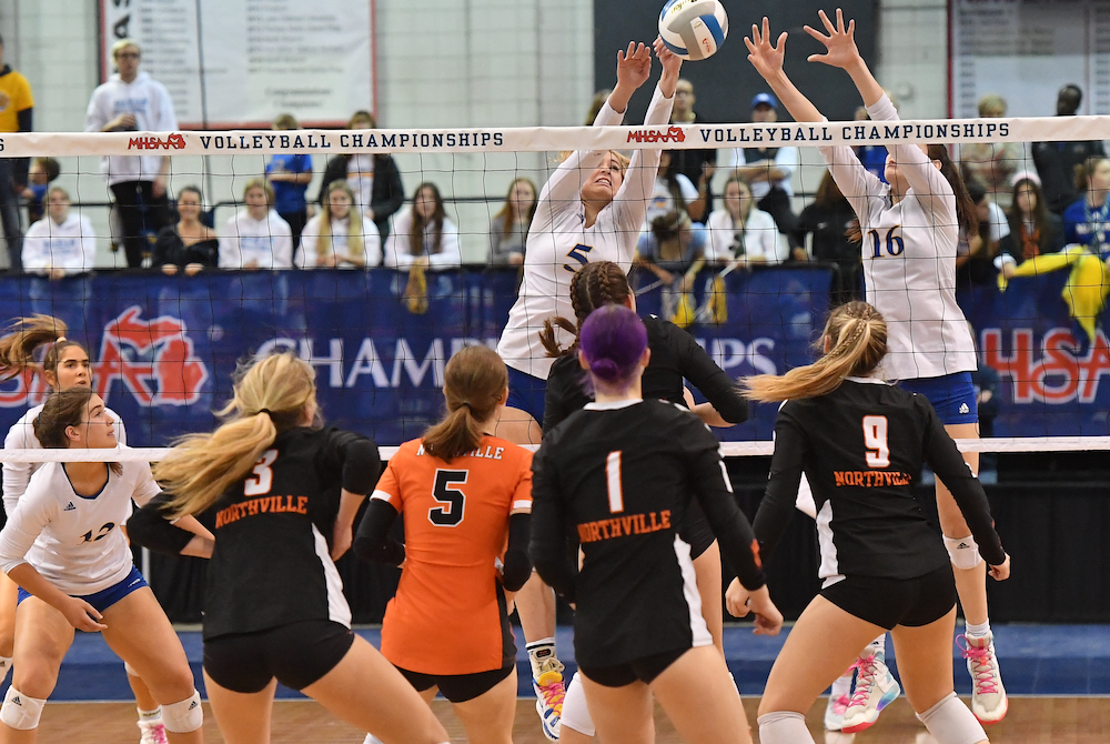 Bloomfield Hills Marian’s Mckenzie Swanson (5) and Izzy Busignani (16) put up a block during the Mustangs’ Division 1 championship match win Saturday. 