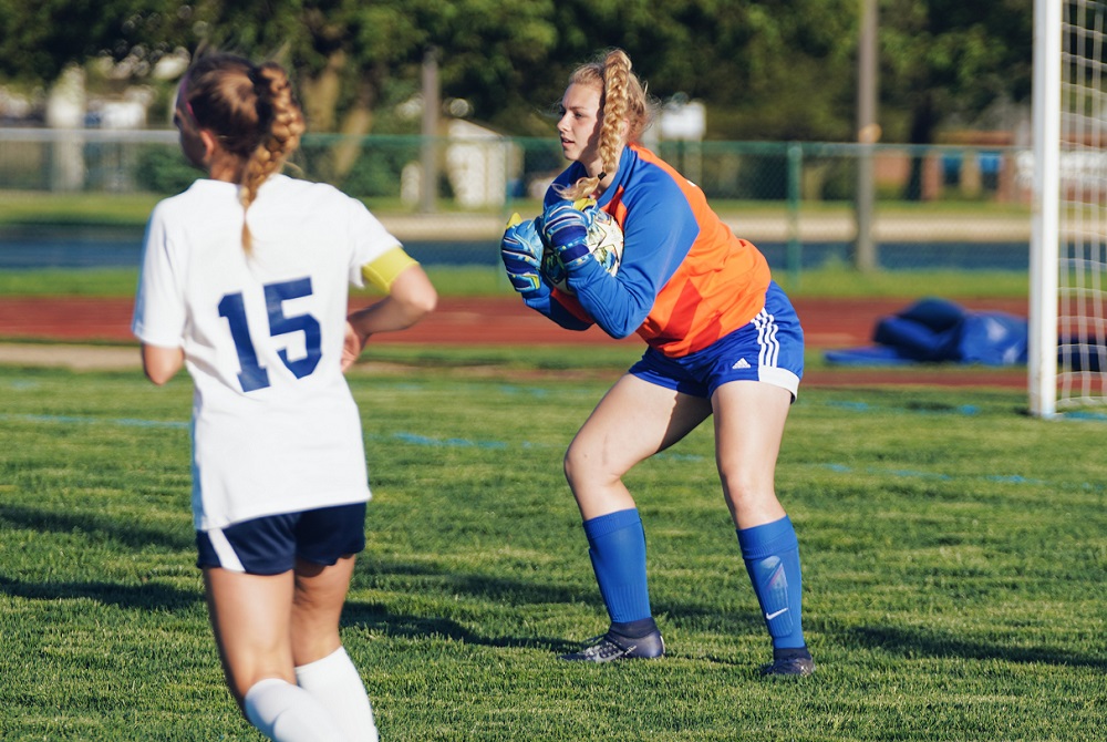 Avery Sluss gathers up the ball while playing keeper for Lenawee Christian’s soccer team. 