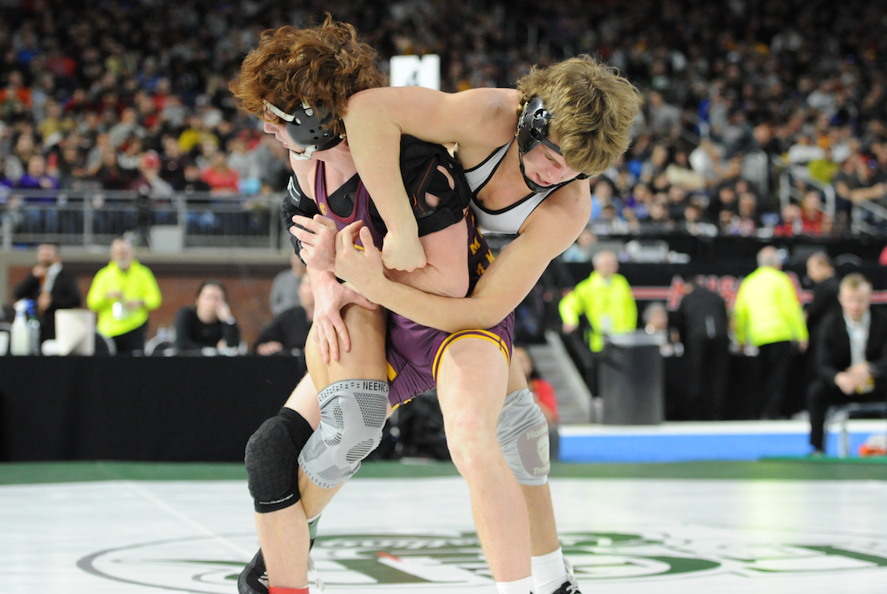 Hudson’s Coy Perry, right, wrestles Manchester’s Blake Sloan during Saturday’s 144-pound title match. 