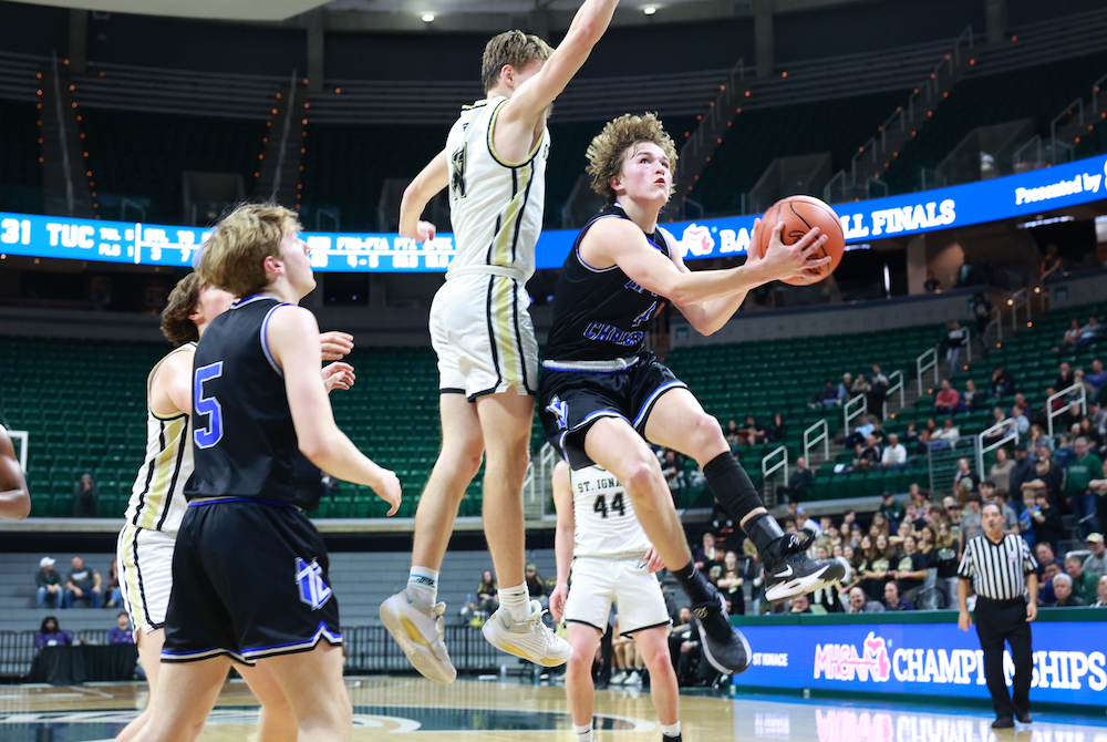 Tri-unity Christian’s Keaton Blanker (4) works to get a shot past the outstretched arms of St. Ignace’s Jonny Ingalls during Thursday’s Division 4 Semifinal.