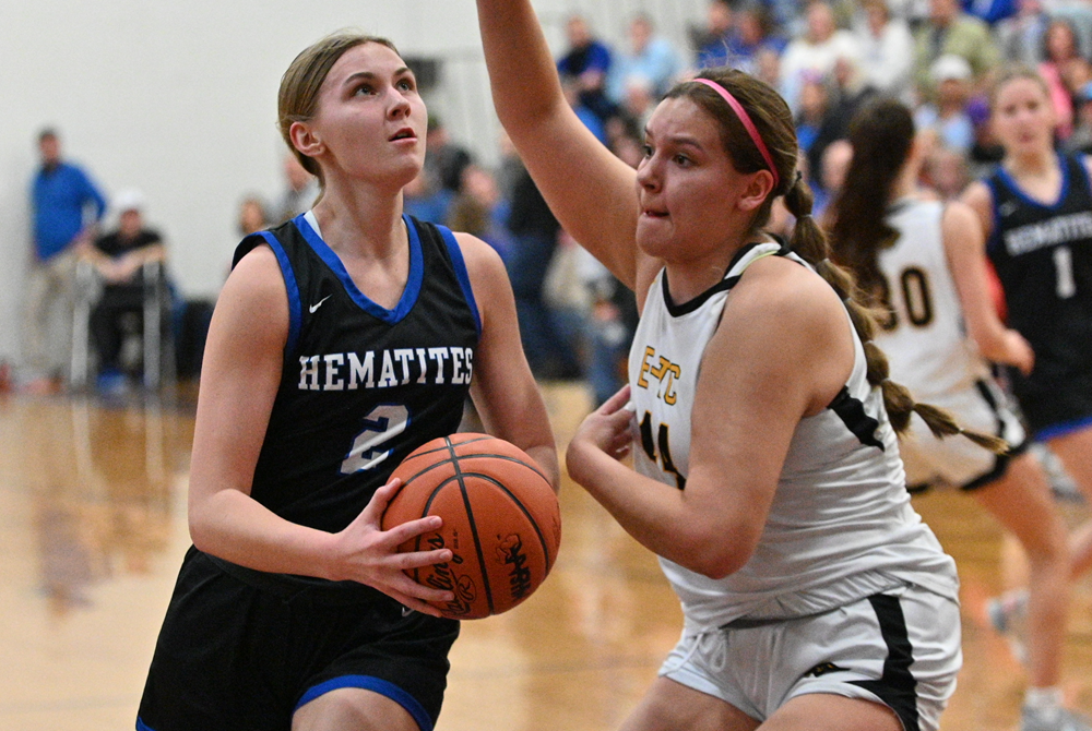 Ewen-Trout Creek's Irelynd McGeshick (44) guards Ishpeming's Addison Morton (2) as she drives to the basket.