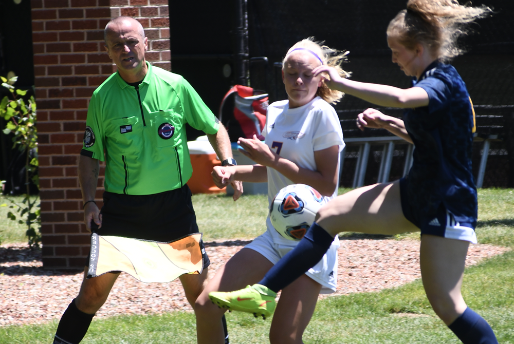 A referee monitors play as two players attempt to gain possession during the 2023 Division 4 Girls Soccer Final.
