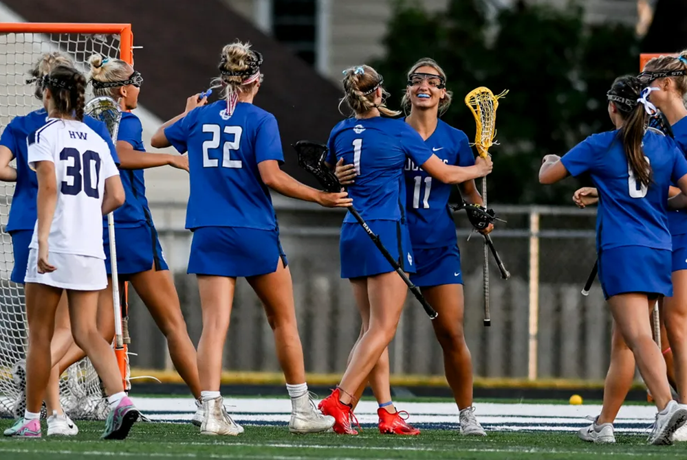 Grand Rapids Catholic Central’s Sarah Rott (11) and Cate Marshall (1) celebrate Marshall’s goal during the first quarter of Wednesday’s Semifinal against Haslett/Williamston. 