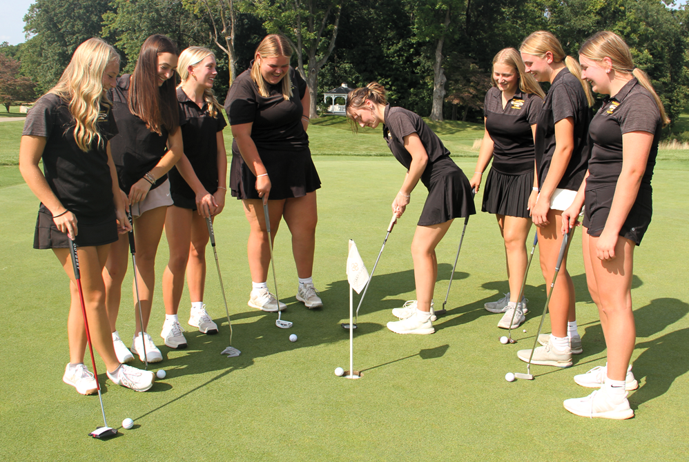 Kalamazoo Christian senior Scarlett Hindbaugh putts during a recent practice, surrounded by teammates (from left) Ella Adams, Lilly Locker, Kennedy Gernaat, Lizzie Yonkers, Kyah Klok, Jordyn Bonnema and Rylee Slater.