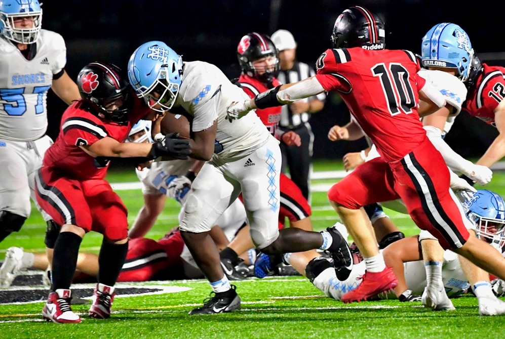 Grand Blanc defenders converge on a Muskegon Mona Shores ball carrier during the Sailors' 28-26 win. 