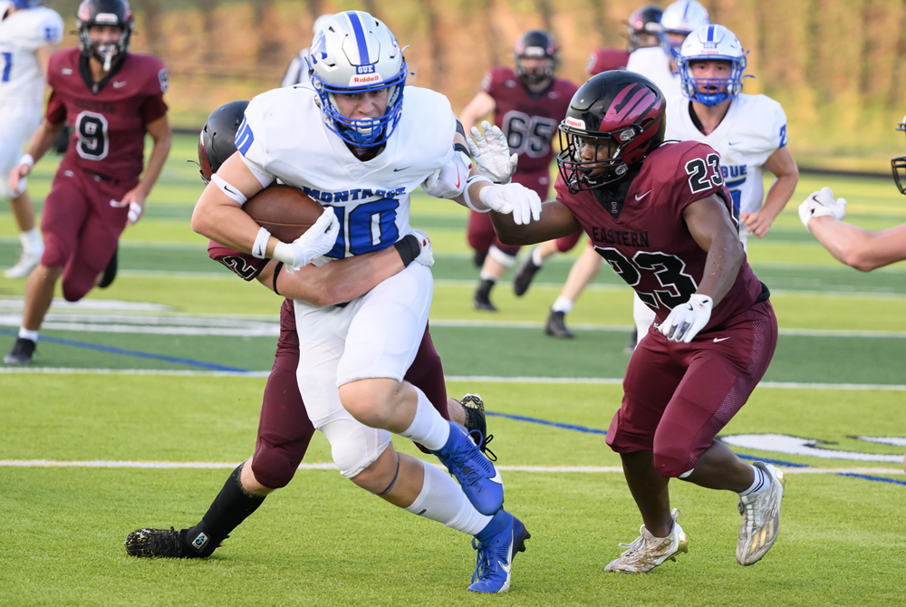 A Montague ball carrier attempts to break free last week from multiple Forest Hills Eastern defenders, including Jordan Shabazz (23). FHE won the opener 48-7.