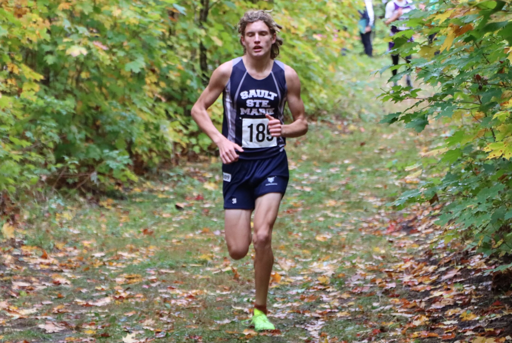 Sault Ste. Marie's Gabe Litzner runs part of a cross country race through a wooded area.