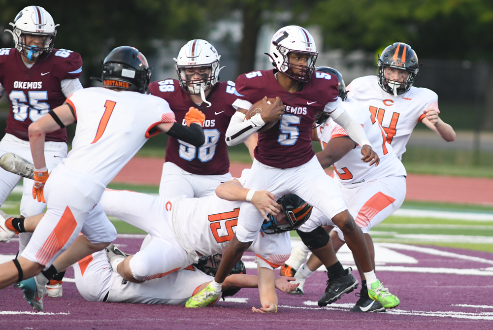 Okemos' Jamaris Graham (5) works to pull away from a Clio tackler Friday.