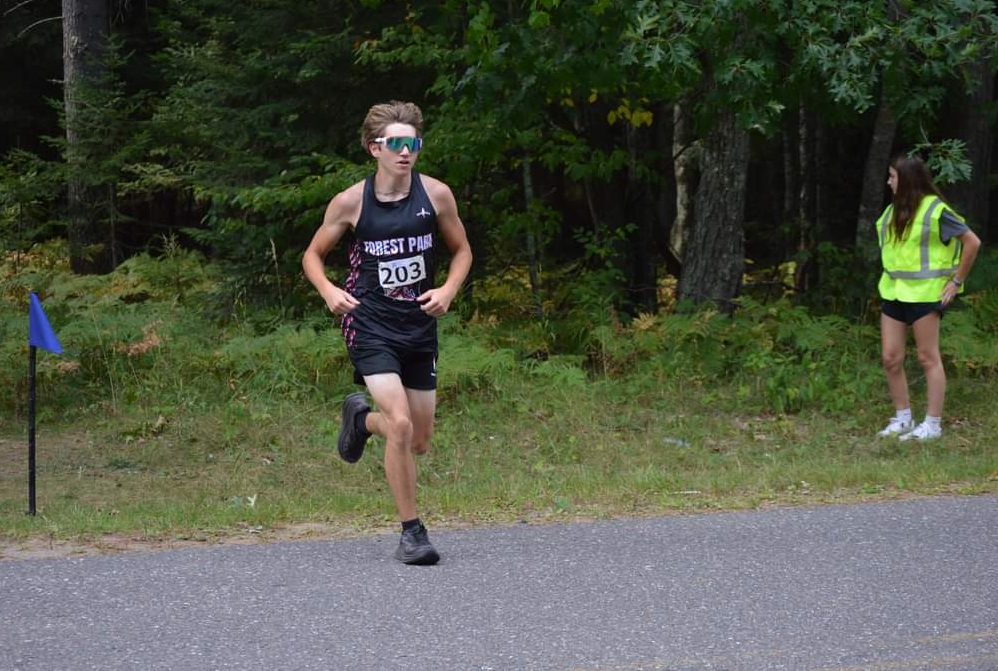 Crystal Falls Forest Park’s Max Mainville crosses a road during his school’s inaugural invitational Sept. 4.