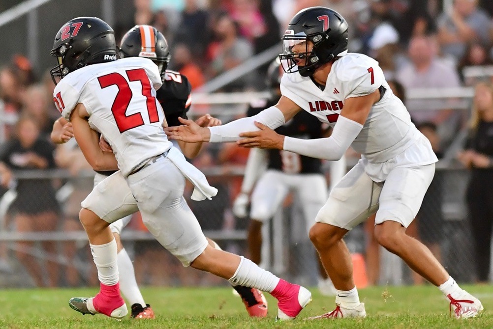 Linden quarterback Dylan Dreasky (7) hands off during his team’s 14-13 win over previously-undefeated Flushing on Friday.