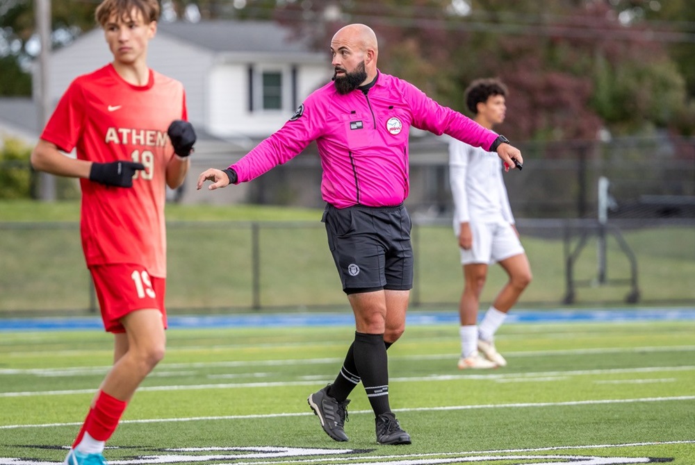 An official crossing the soccer field looks back toward the sideline during Monday's Berkley/Troy Athens District game.