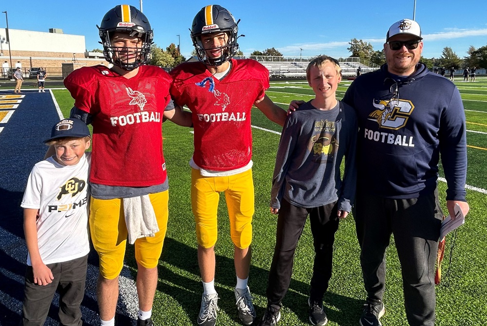 From left, Ty Pettit, quarterbacks KaLenn Harsh and Dominic Wing, Lawson Westinghouse and Cadillac football coach Nick Winkler take a moment for a photograph during a recent practice.