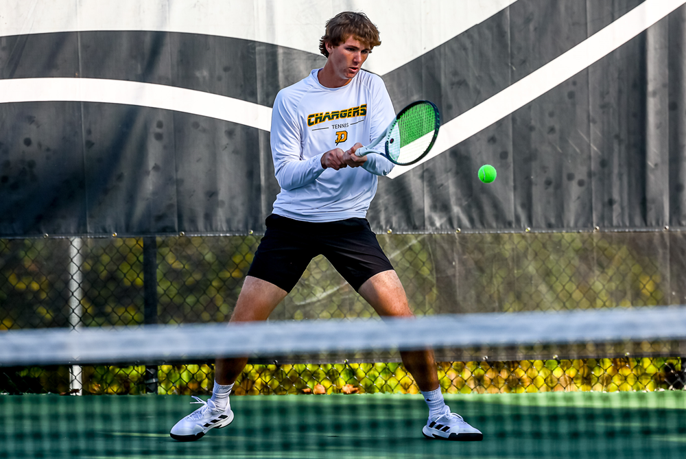 Midland Dow's Austin King hits a backhand during an early No. 1 singles match Friday at Kalamazoo College.