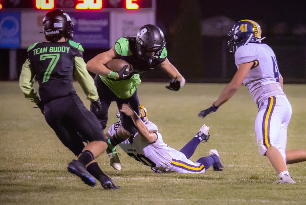 A pair of Ovid-Elsie defenders close in on New Lothrop’s Michael Schachter (9) during the Marauders’ 42-0 Week 8 victory. 