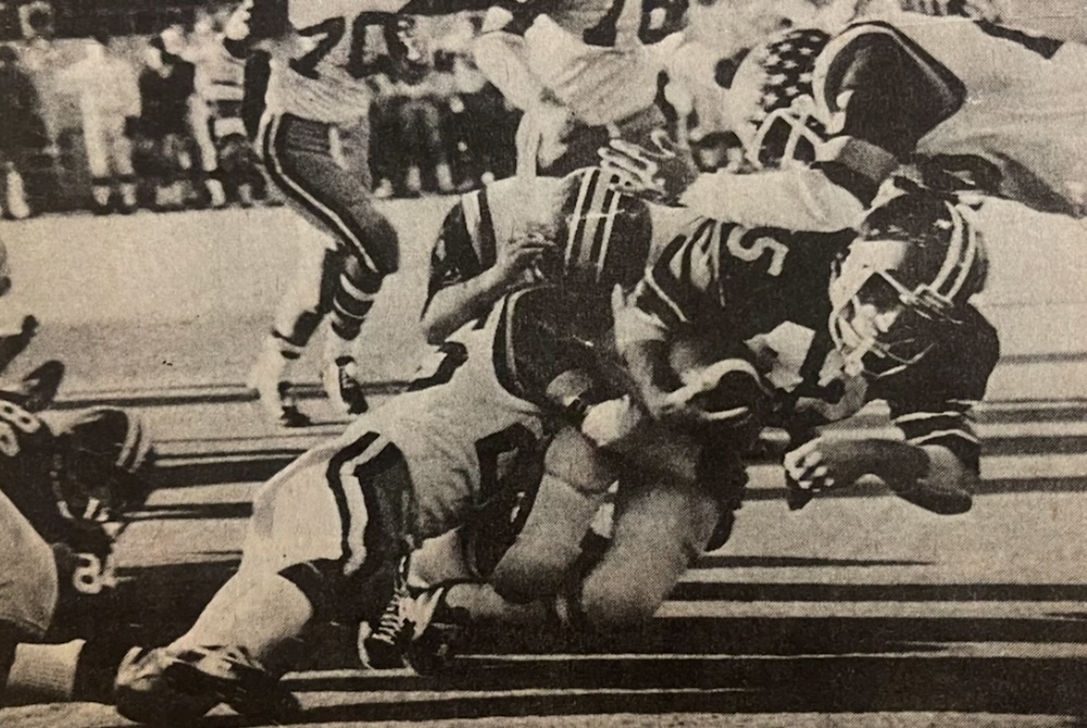 Livonia Franklin’s Jim Casey (45) plows ahead during the 1975 Class A Final as Traverse City tacklers converge.