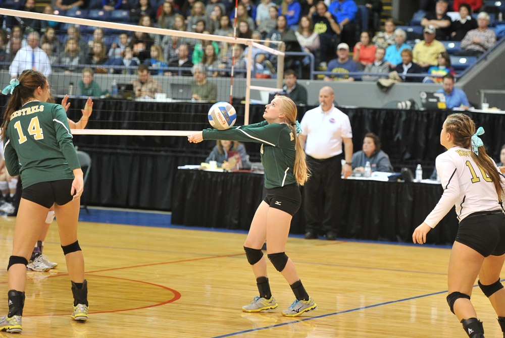 A Monroe St. Mary Catholic Central player bumps a volleyball near the net during the 2015 Class C Final. 