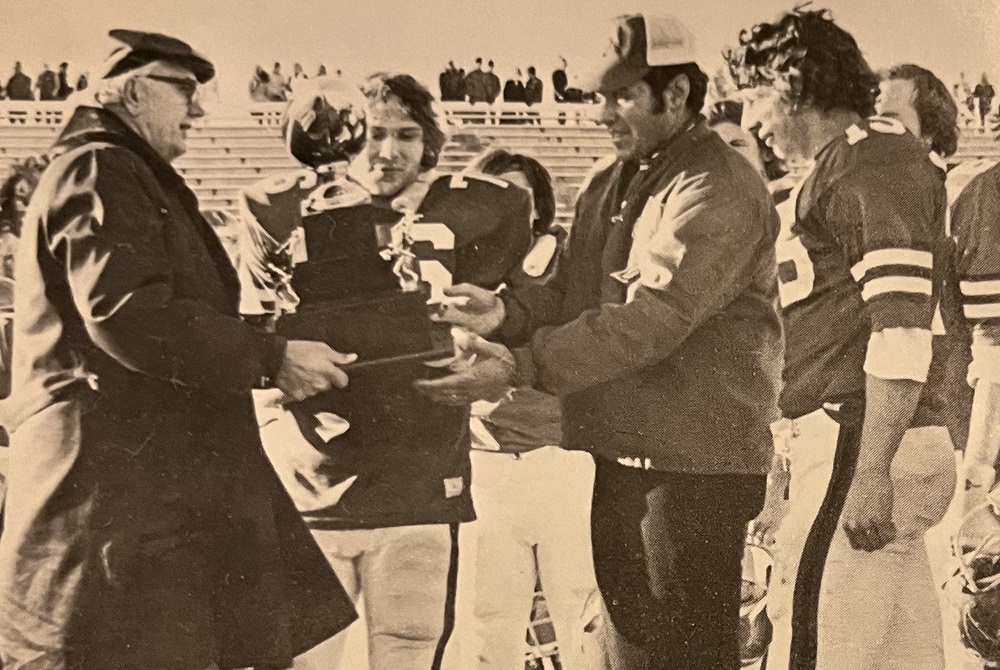 Dearborn Divine Child coaches and players receive the Class B championship trophy after winning the inaugural title game in 1975.