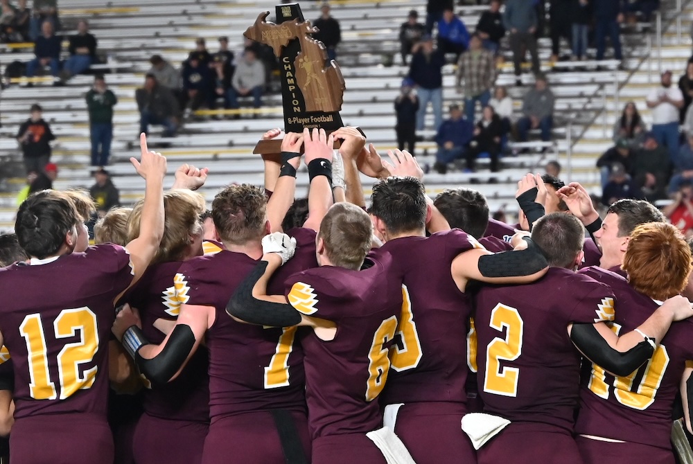 Deckerville players huddle around their championship trophy Saturday at the Superior Dome.