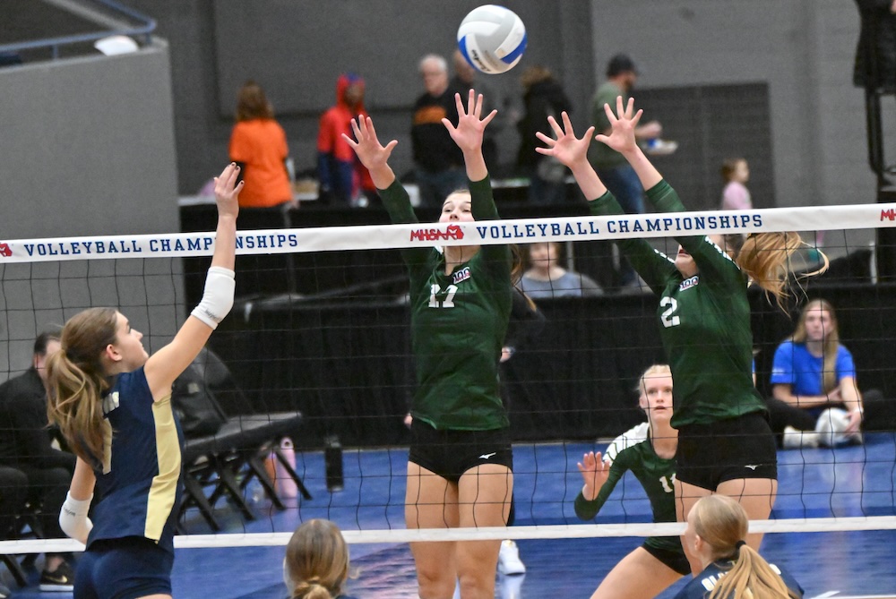 Monroe St. Mary’s McKenna Payne (11) and Olivia Beaudrie (2) wall off the top of the net as Traverse City St. Francis’ Landry Fouch (7) connects during Saturday’s Division 3 Final. 