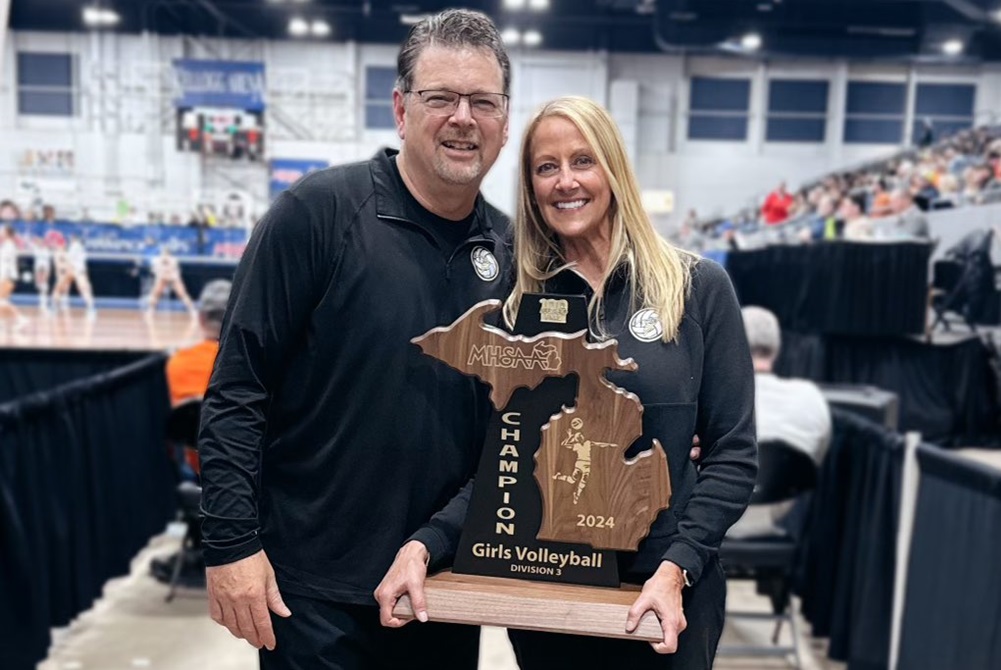 Monroe St. Mary Catholic Central head volleyball coach Kim Windham, right, and assistant coach/husband Randy hold the program’s latest championship trophy. 