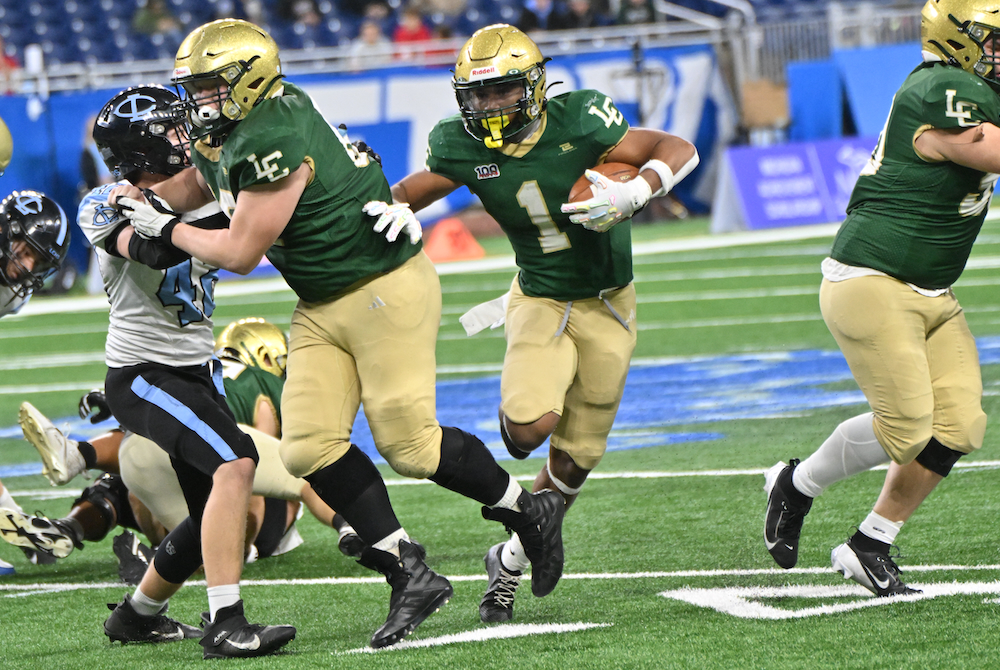 Lumen Christi’s Kadale Williams (1) follows his blocker into an opening Saturday at Ford Field.