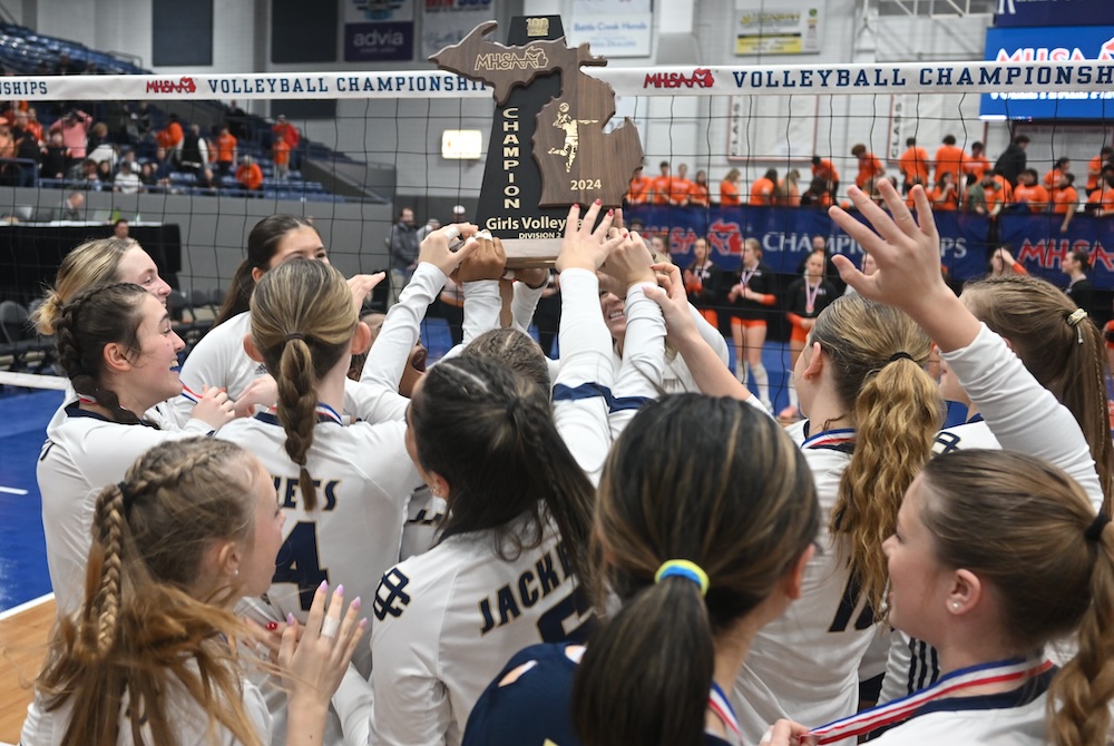 Detroit Country Day players raise their championship trophy Saturday night at Kellogg Arena. 