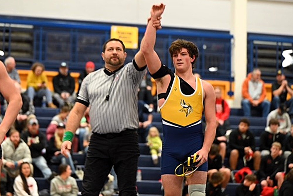 An official raises Luke Phillips' arm in victory after his match this season against Charlevoix.