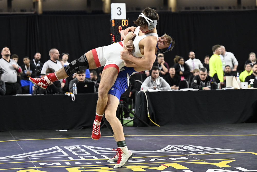 Dundee’s Jeremy Amrhein, in blue, hoists his opponent into the air during their Division 3 championship match.