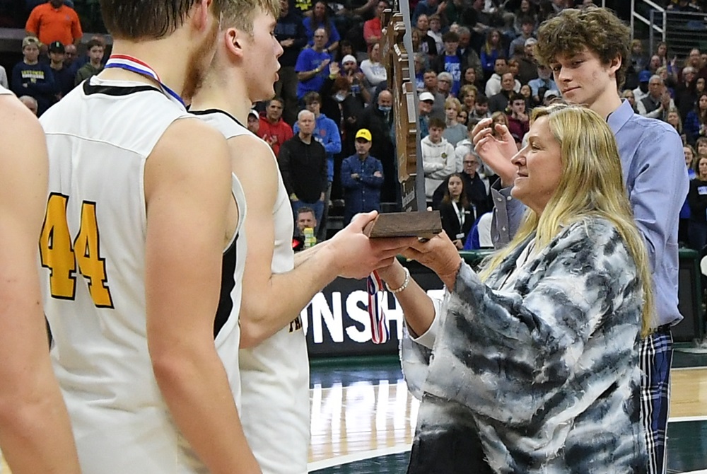 Retired Adrian Madison athletic director Kristen Isom presents the Division 4 finalist trophy to Ewen-Trout Creek in 2022.