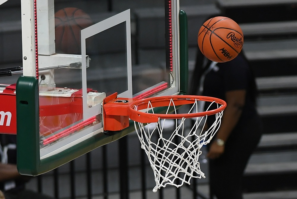 A basketball floats toward a basket as the lights around the backboard are lit signaling the buzzer.