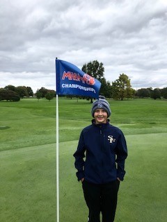 Slocum stands next to a flag during last season’s MHSAA Girls Golf Finals. 