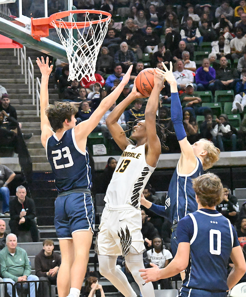 Christopher Williams (13) tries to power past South Christian’s Sam Weiss (23) to the rim.