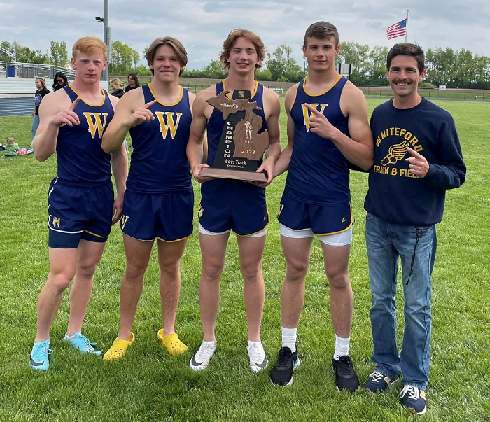  The 1,600 relay of Shea Ruddy, Dylan Anderson, Ryin Ruddy and Jake Iott show off their latest trophy with Whiteford coach Jay Yockey after the Bobcats claimed their first Regional track & field team title since 2007. (
