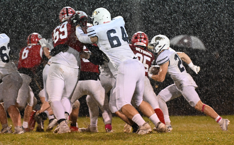 An Otsego rusher charges into the line during a rainy 47-6 win by Paw Paw.