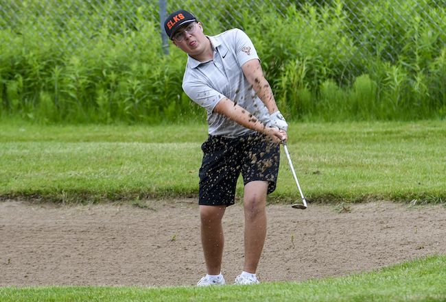Elk Rapids’ Baron Vollmer sends his ball out of the sand. 