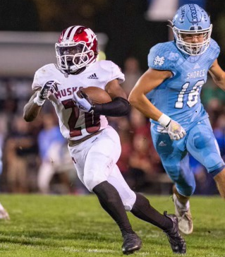 Muskegon's Jakob Price (left) makes a move on the way to a 99-yard touchdown run against Muskegon Mona Shores in 2021.