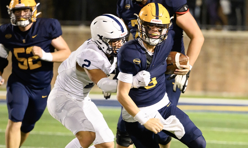 Grand Rapids South Christian's Owen Burgess (2) works to wrap up an East Grand Rapids ball carrier. 