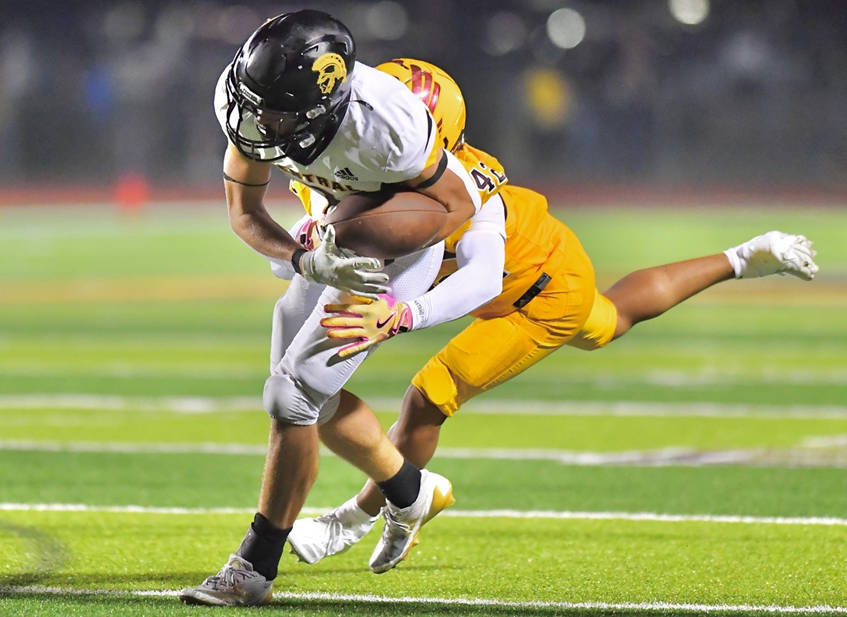 A Traverse City Central ball carrier works to secure possession during a 49-14 loss to Davison.