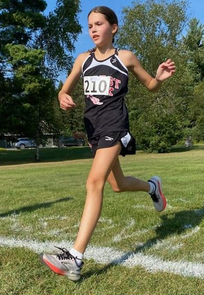 The Trojans’ Ellie Zaupa crosses the finish line.