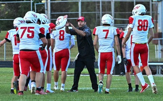 Jayhawks coach Daniel Midena, middle, high-fives his players.