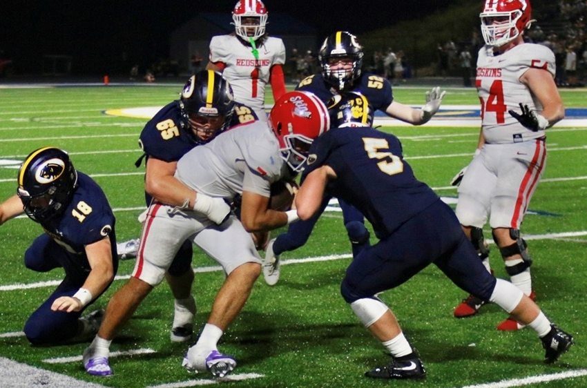 DeWitt’s Tyler Dusseau (65) and Max Holtz (5) bring down a ball carrier from Hurricane, WV.