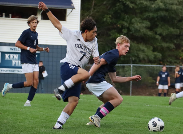 Packard battles a Godwin Heights player for possession as Jayden Booker looks on.