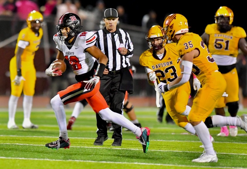 Grand Blanc’s Caseton Sendry (18) eludes a pair of Davison defenders. 