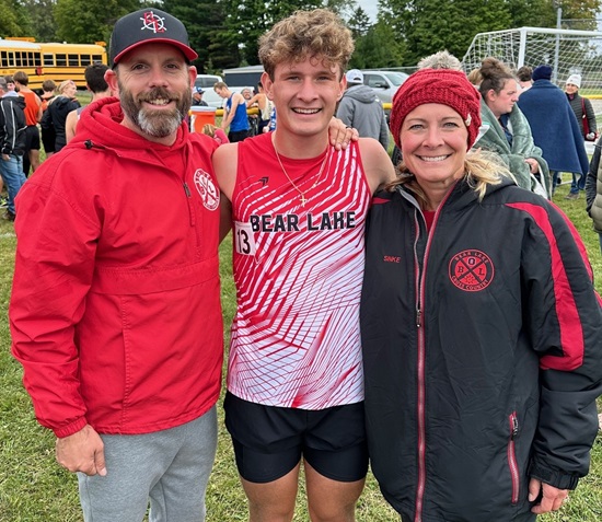 Mason Sinke, middle, takes a photo with Bear Lake head coach Tony Shrum and assistant and mother Kim Sinke.