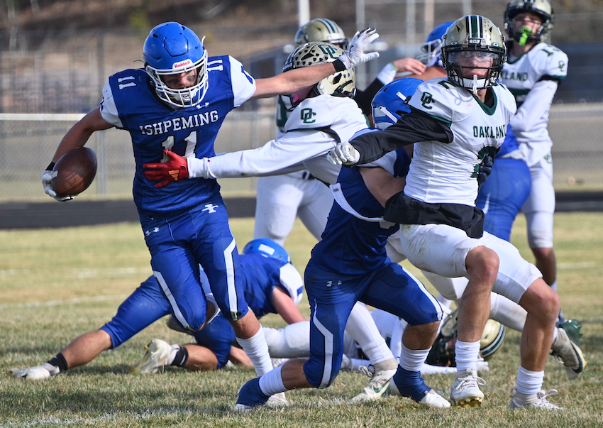 Ishpeming's Ethan Corp works to get past an Auburn Hills Oakland Christian defender Saturday during the Hematites' 58-6 victory. 