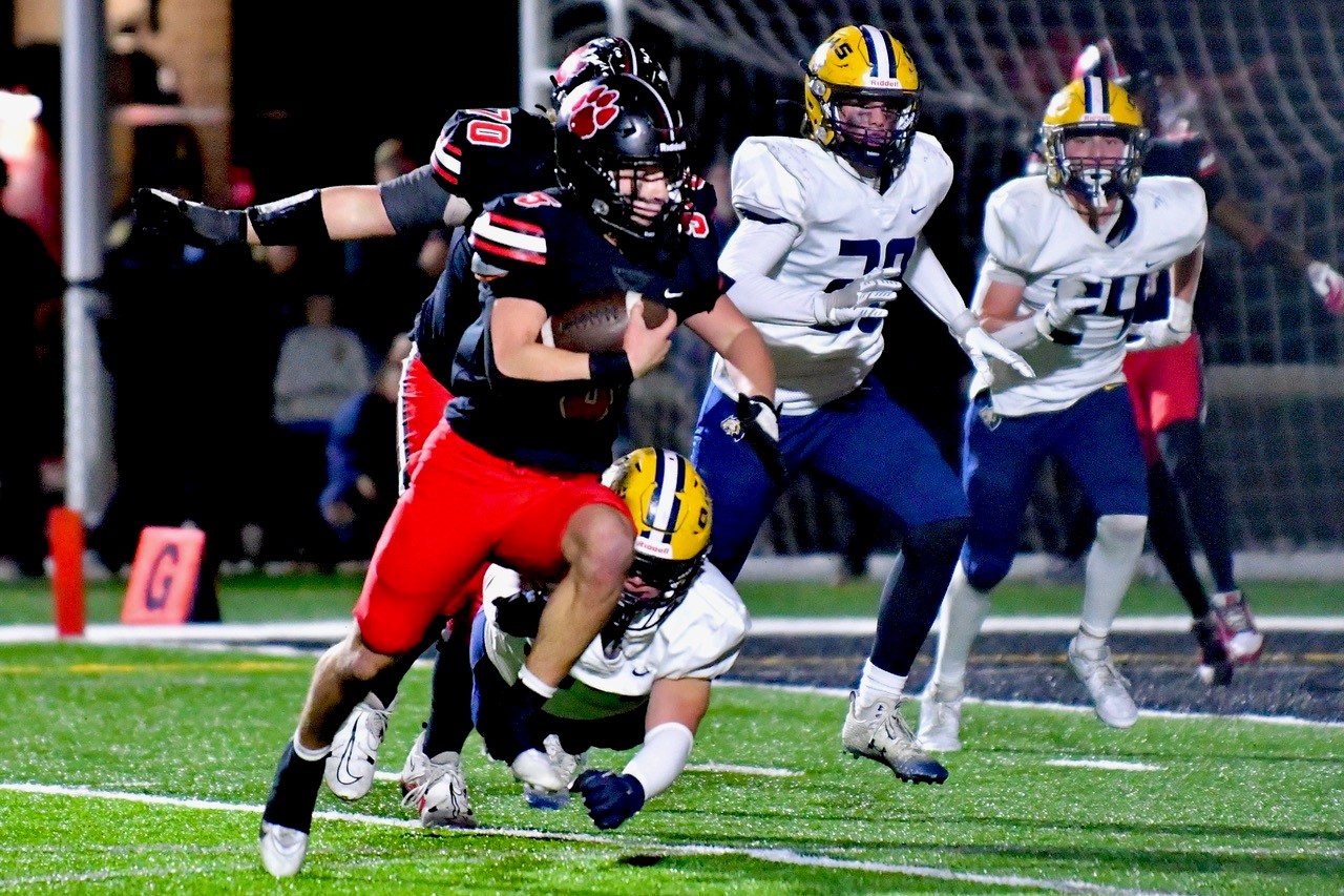 Grand Blanc’s Nik Lemons (5) finds the edge as Oxford tacklers pursue. 