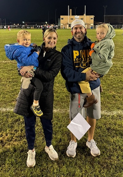 Roelens holds daughter Audrey, and wife Kelsey holds son Brady on the field. 