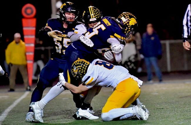 Goodrich’s Chase Burnett (25) takes on a pair of Haslett defenders.